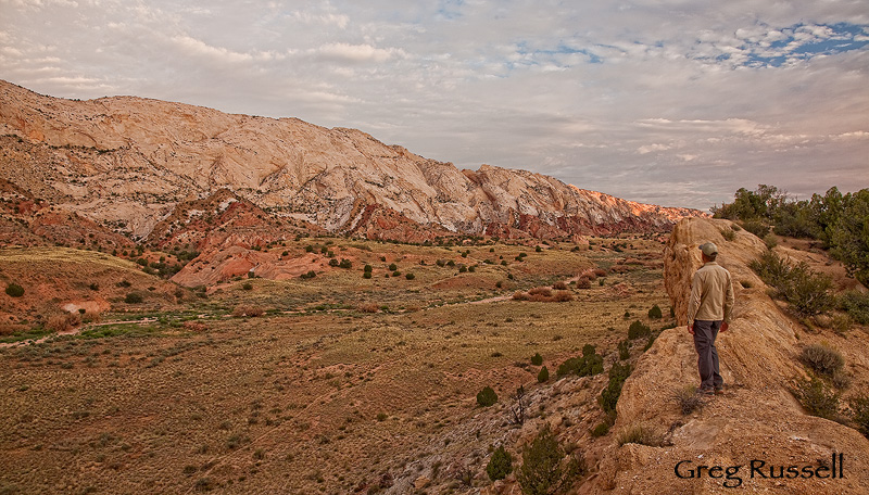 a hiker stands in waterpocket fold country, notom-bullfrog road, capitol reef national park, utah