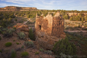 A small ruin is nestled on top of a large boulder as part of the largo canyon complex in northwestern New Mexico
