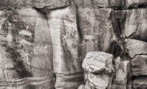 Black and white image of a Navajo (Diné) rock art panel depicting anthropomorphous and other nonhuman figures.