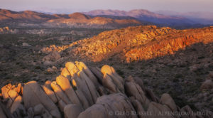 rock outcroppings called inselbergs stretch for miles as the sun sets across the Mojave Desert